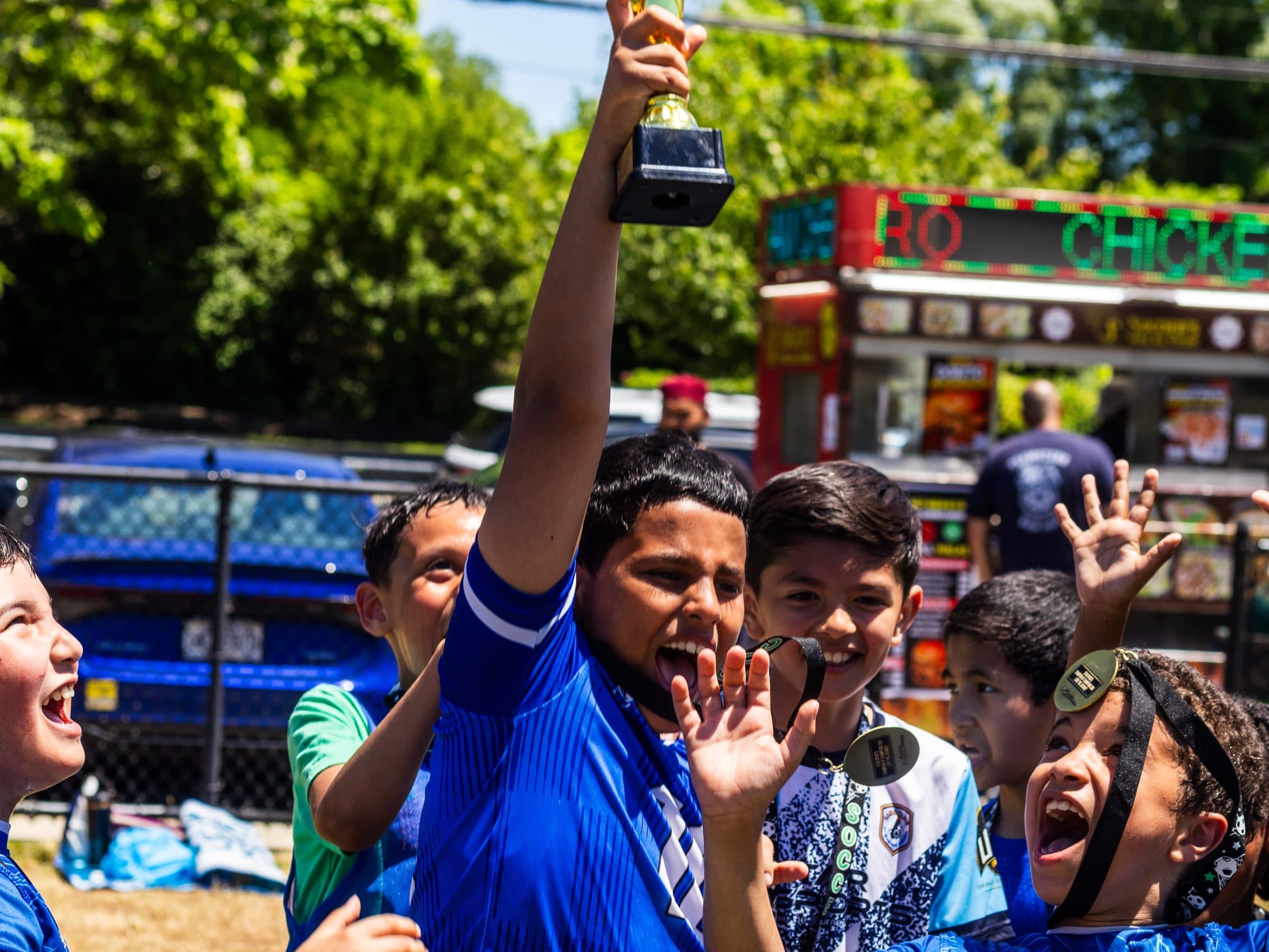 A Star Sports player lifts a trophy as teammates cheer